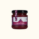 Jar of quince paste with a purple label on a white background
