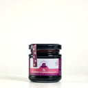 A glass jar of Mulberry & Lemon Balm Jam with a black lid and a pink and white label, wrapped in a matching pink paper band with paw prints, on a white background.