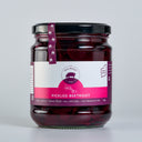 A glass jar of The Mulberry Pig Pickled Beetroot with a black lid and a white, pink, and purple label, set against a plain light gray background.