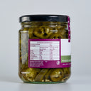 A glass jar of The Mulberry Pig Pickled Jalapeños with a black lid and a white, dark green, and purple label showing nutritional value, set against a plain light grey background.