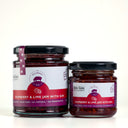 Two glass jars of Raspberry & Lime Jam with Gin from The Mulberry Pig, one large and one small, with white and purple labels and black lids, set against a light gray background.