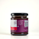 A glass jar of The Mulberry Pig Strawberry Cinnamon Jam with a black lid, showing the back label with a barcode, 'Made in WA' logo, and product details on a white background.