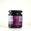 A jar of the mulberry pig blueberry and lavender jam, showing the description label with purple branding and light blue product stripe.