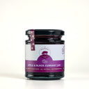 A glass jar of The Mulberry Pigs Apple & Black Currant Jam with a black lid and a purple label, set against a plain light gray background.