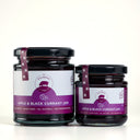 Two glass jars of The Mulberry Apple and Blackcurrant jam, one large and one small, with purple and white labels and black lids, set against a light gray background.
