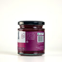 A glass jar of Beetroot Relish by The Mulberry Pig, featuring a black lid, a white and magenta label with product description, set against a plain white background.