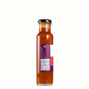 A glass bottle of The Mulberry Pig 
Handmade Chilli Garlic Sauce with Fenugreek, featuring a white and red label showing ingredients and nutritional panel with a purple accent ribbon, set against a plain white background.