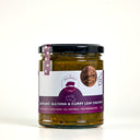 A Large glass jar of eggplant, sultana & curry leaf chutney by The Mulberry Pig, featuring a black lid and a white and purple label with a bronze medal , set against a plain white background.