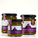 Three glass jars of The Mulberry Pig Eggplant, Sultana & Curry Leaf Chutney arranged on a white surface against a white background.