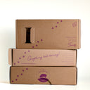 Stacked kraft gift boxes with The Mulberry Pig logo