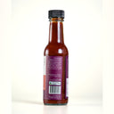Back view of a glass bottle of the Mulberry Pig Slow smoke hot sauce with a black cap and a purple label, showing the text and barcode on a white background.
