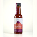 A bottle of Mulberry Pig Slow Smoke Hot Sauce on a clean white background. The glass bottle shows the reddish-brown sauce inside, featuring a white and red label with a purple brand logo and a black cap.