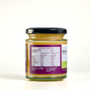 A glass jar of 'The Mulberry Pig' Lemoncello Curd with Gincello, featuring a black lid, a purple and white label with green accents showing nutritional information, and a purple paper seal, set against a plain white background.