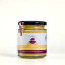 A glass jar of The Mulberry Pig Lemon Curd with Australian Vanilla on a clean white background. The jar contains a pale yellow curd, has a black lid, and a white label with purple accents.