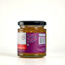 A glass jar of "The Mulberry Pig" Blood Orange and Ginger Marmalade, showing the back of the label with product details, set against a clean light gray background.