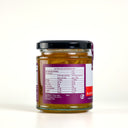 A glass jar of "the Mulberry Pig" Blood Orange and Ginger Marmalade with a black lid, showing the back of the label with nutrition information. The jar is set against a clean, light gray background.
