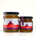 Two glass jars of The Mulberry Pig Blood Orange and Ginger Marmalade on a light gray background.