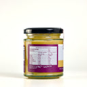 A glass jar of The Mulberry Pig Passionfruit Curd with a black lid and a white and gold label with nutritional information, set against a plain cream background.