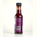 Back of a bottle of The Mulberry Pig Salted Plum & Black Pepper Worcestershire Sauce with a purple label suggesting it on cheese on toast, a sausage sandwich, steak and eggs or bolognaise, marked Made in WA, set against a plain cream background.