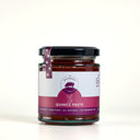 A glass jar of 'The Mulberry Pig' Quince Paste on a light cream background. The jar contains deep red quince paste, has a black lid, and a white and magenta label with a purple ribbon seal.