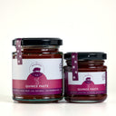 Two glass jars of Quince Paste by The Mulberry Pig, one large and one small, with black lids and purple labels, set against a light Cream background.