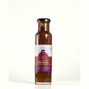 A glass bottle of 'The Mulberry Pigs' lightly smoked BBQ sauce with Fennel and celery seed, featuring a white and dark red label with a purple accent ribbon, set against a plain white background.