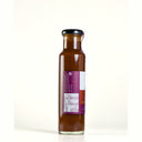A glass bottle of The Mulberry Pigs  Lightly Spiced BBQ Sauce with a black cap and a purple and white label showing nutrition and ingredients, set against a plain white background.