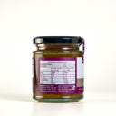 A glass jar of The Mulberry Pig smoked onion marmalade shown from the back, featuring a black lid, a brown contents visible through the glass, and a prominent purple label with nutritional information.