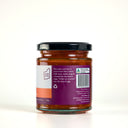 A glass jar of Mulberry Pig Sweet Chilli Jam with a black lid and a white, orange, and purple label showing the description , set against a plain white background.