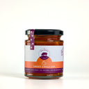 A glass jar of Mulberry Pig Sweet Chilli Jam with a black lid and a white, orange, and purple label, set against a plain white background.