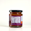 A glass jar of Mulberry Pig Sweet Chilli Jam with a black lid and a white, orange, and purple label showing the nutrition panel, set against a plain white background.